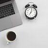 foto de laptop, relógio e xícara de café