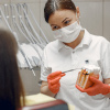 Dentista ensina cuidados adequados à paciente ou estudante (Imagem de prostooleh no Freepik)